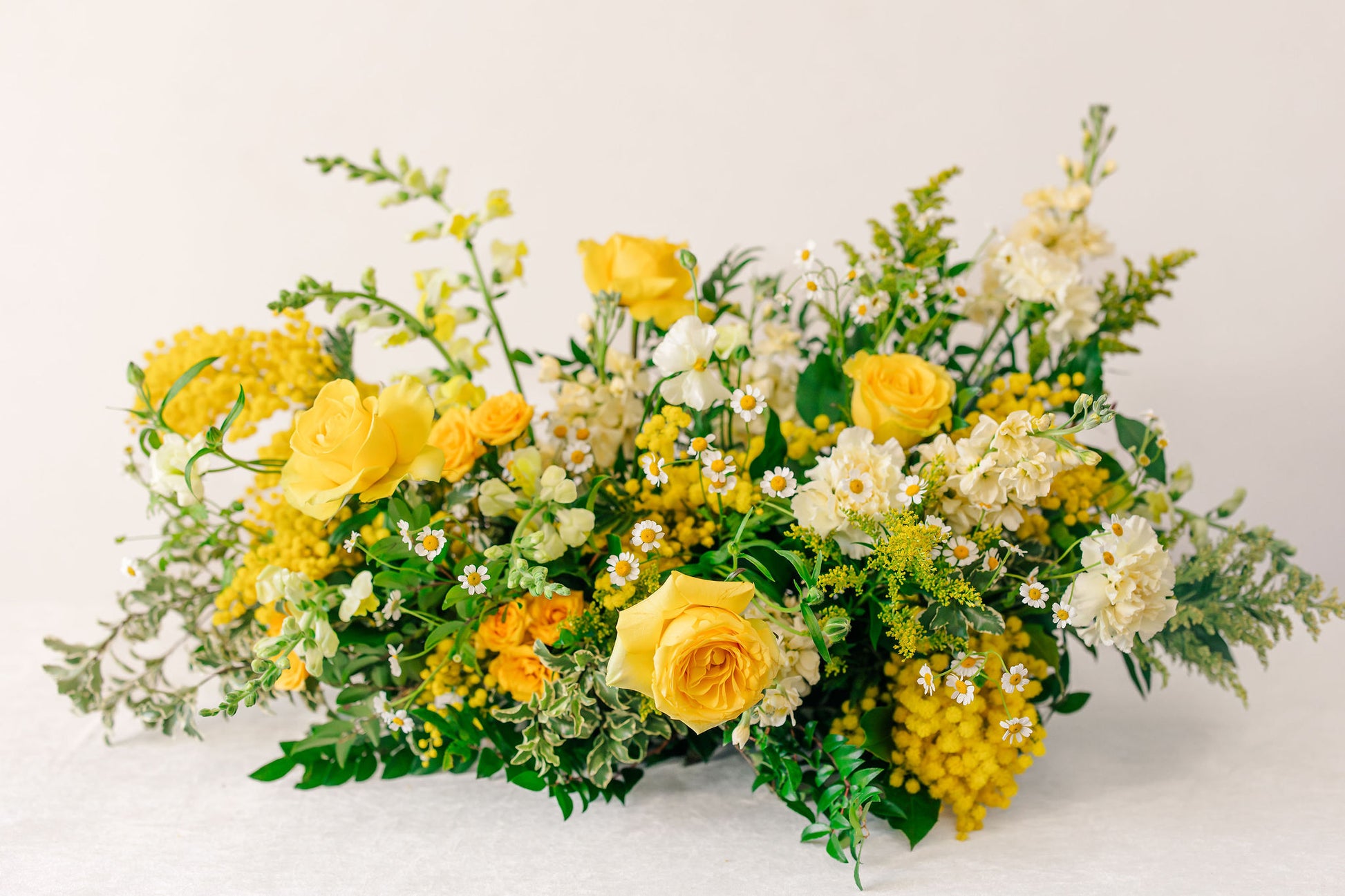 Large yellow flower arrangement on a white background
