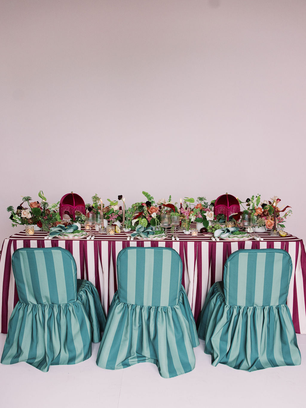 Table set with striped tablecloth and chairs against a white background