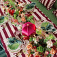 Decorative table setting with floral arrangements and striped tablecloth