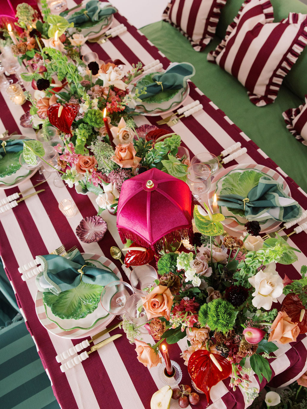 Decorative table setting with floral arrangements and striped tablecloth